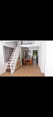 a white staircase in a room with a table and a piano at Attuvam Valley in Kodaikānāl