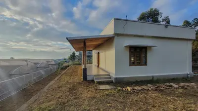 a small white building with a black roof at Home stay in Kanthalloor