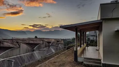 a house with a balcony with a view of the mountains at Home stay in Kanthalloor