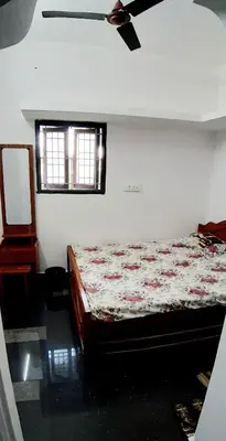 a bedroom with a bed and a ceiling fan at Hotel Rams in Coimbatore
