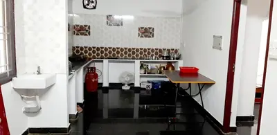 a small kitchen with a sink and a table at Hotel Rams in Coimbatore