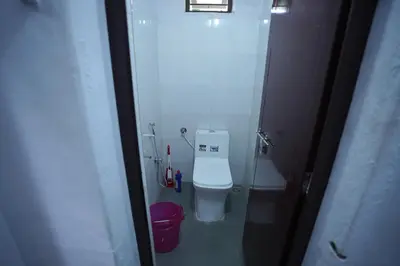 a bathroom with a white toilet in a stall at Koodapuzha House Chalakudy in Kizhake Chālakudi