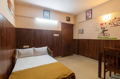 a bedroom with a bed and a wooden wall at Sancta Maria Airport Suites in Nedumbassery