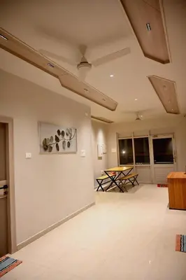 a living room with a table and a ceiling at K.K RESIDENCY in Palakkad