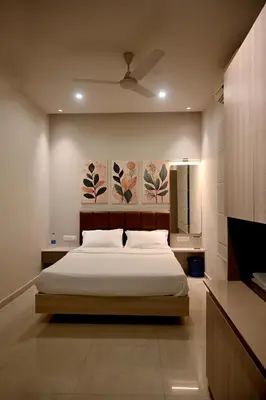 a bedroom with a bed and a painting on the wall at K.K RESIDENCY in Palakkad