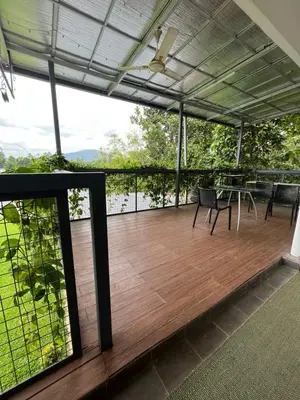 a patio with a table and chairs on a deck at River View Apartments a Pet Friendly Retreat in Ernakulam