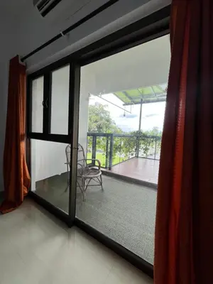 a room with a window and a chair on a balcony at River View Apartments a Pet Friendly Retreat in Ernakulam