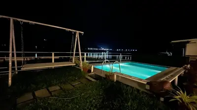 a swimming pool at night with a fence around it at River View Apartments a Pet Friendly Retreat in Ernakulam