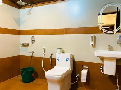a bathroom with a toilet and a sink at Captain's Cove Home Stay in Sultan Bathery