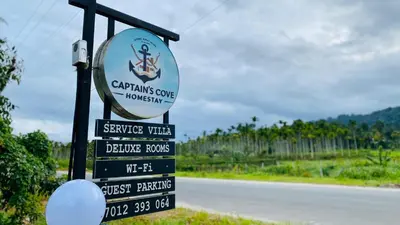 a sign for a wine estate on the side of a road at Captain's Cove Home Stay in Sultan Bathery