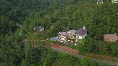 an aerial view of a house in the middle of a forest at Mizzle Resort in Padinjarathara