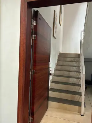 a wooden door in a room with a staircase at Thottan house in Trichūr