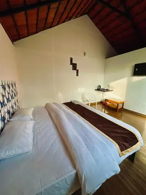 a bedroom with a large bed and a table at Josh Holidays Wayanad in Vaduvanchal
