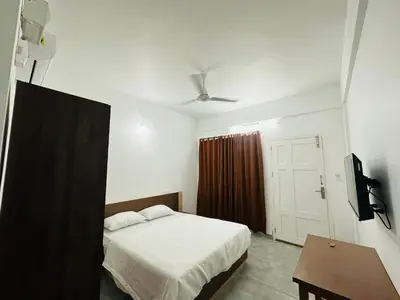 a bedroom with a bed and a table and a tv at Jayalakshmi Residency in Vaduvanchal