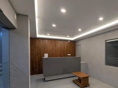 a room with a large tv and a wooden wall at Jayalakshmi Residency in Vaduvanchal