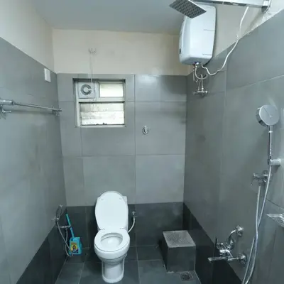 a bathroom with a white toilet and a shower at A4, Melam, Hima Havens- 200 m from Guruvayoor Temple in Guruvāyūr