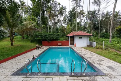 a swimming pool in a yard with a house at Exuberance Villa in Batheri