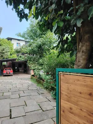 a wooden fence in front of a yard with a tree at NIT Calicut Apartment in Tāzhekkod