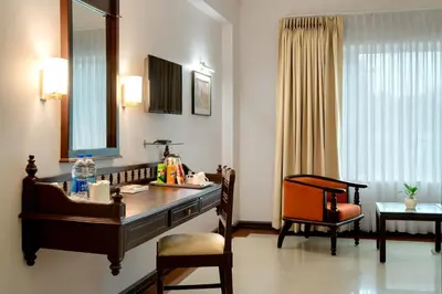 a room with a desk with a mirror and a chair at Hyson heritage calicut in Kozhikode