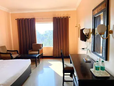 a hotel room with a bed and a desk at Hyson heritage calicut in Kozhikode