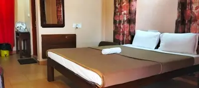 a bedroom with a bed with white pillows at Holidayincoorg - Brick lane in Madikeri