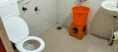 a small bathroom with a toilet and a sink at Holidayincoorg - Brick lane in Madikeri
