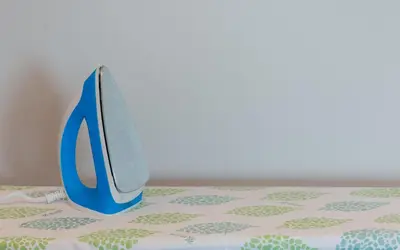 a blue pair of scissors sitting on a table at Apple Inn in Pollāchi