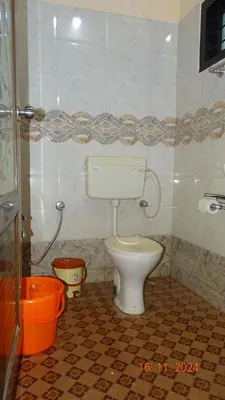 a bathroom with a white toilet in a room at Nirmalyam Homestay in Kuttippuram