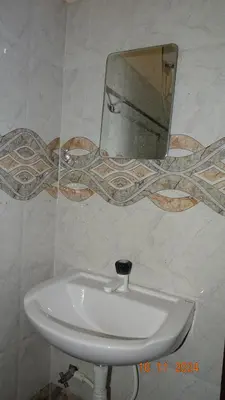 a bathroom with a sink and a mirror on the wall at Nirmalyam Homestay in Kuttippuram