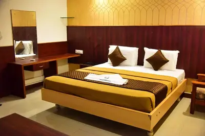 a hotel room with a bed and a mirror at Rajalakshmi Comforts Mysuru in Mysore