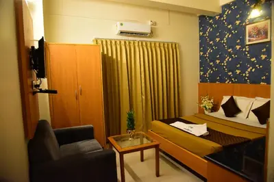 a small room with a bed and a chair at Rajalakshmi Comforts Mysuru in Mysore