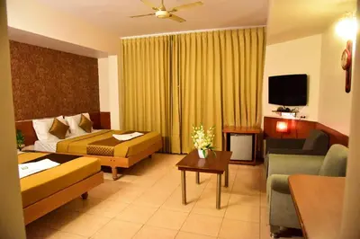 a hotel room with a bed and a living room at Rajalakshmi Comforts Mysuru in Mysore