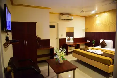 a hotel room with a bed and a table at Rajalakshmi Comforts Mysuru in Mysore