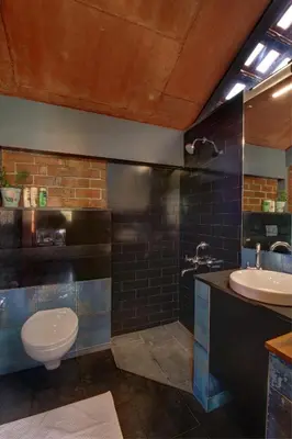 a bathroom with a toilet and a sink at Vettaths in Kozhikode