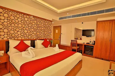 a bedroom with a large bed and a kitchen at Seaflare Beach Resort & Spa in Pallipuram