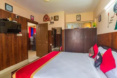a bedroom with a large bed with red pillows at Mayflower Airport Launge cochin international airport in Nedumbassery