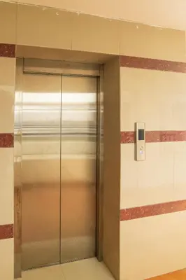 an elevator in a building with red stripes at Mayflower Airport Launge cochin international airport in Nedumbassery