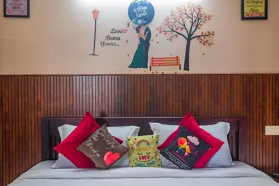 a bed with colorful pillows on top of it with a wall at Mayflower Airport Launge cochin international airport in Nedumbassery