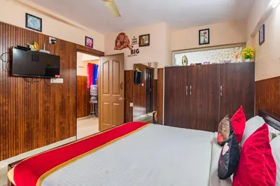 a bedroom with a large bed with red pillows at Mayflower Airport Launge cochin international airport in Nedumbassery