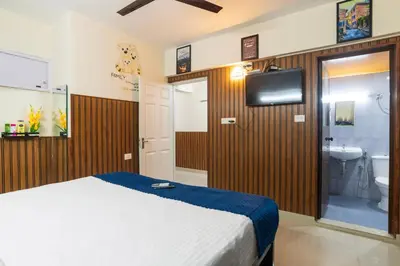 a bedroom with a bed and a bathroom with a sink at Mayflower Airport Launge cochin international airport in Nedumbassery