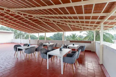 a restaurant with tables and chairs on a roof at Treebo Sanmaya Retreat, 15 Mins From Mysore Palace in Mysore