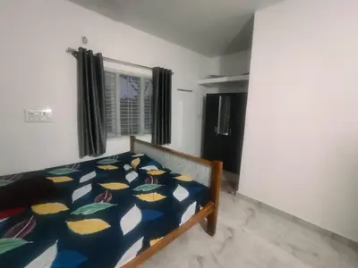 a bedroom with a bed with a blue comforter at Suggi Farm House in Halgūr