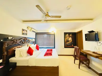 a bedroom with a bed with red pillows and a desk at City Palace Residency Nilambur in Wandūr