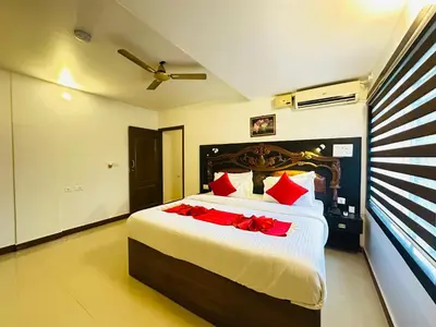 a bedroom with a large bed with red pillows at City Palace Residency Nilambur in Wandūr