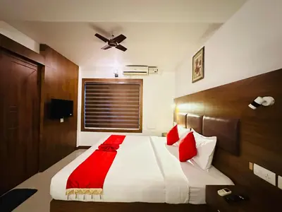 a bedroom with a large white bed with red pillows at City Palace Residency Nilambur in Wandūr