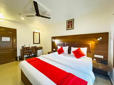 a bedroom with a large bed with red pillows at City Palace Residency Nilambur in Wandūr