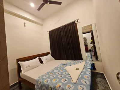 a small bedroom with a bed and a ceiling fan at Bricknest hillview in Mysore