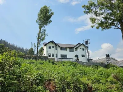 a white house sitting on top of a hill at Shangrila Casa-Premium Homestay in Lovedale