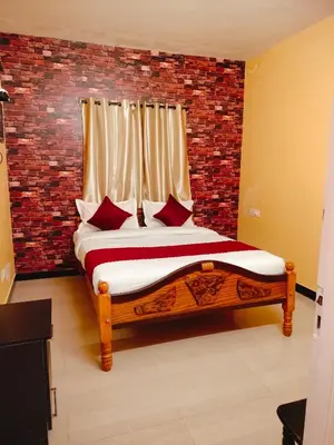 a bedroom with a bed with a brick wall at Harvest Hill View Cottage in Ooty