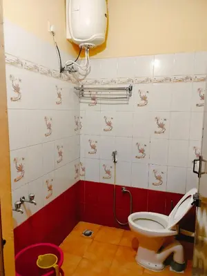 a bathroom with a toilet and a sink at Harvest Hill View Cottage in Ooty